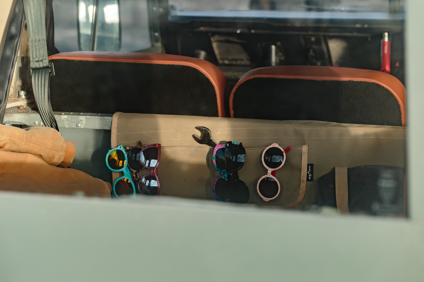 Sunglasses hanging in a tool roll inside a classic Land Rover