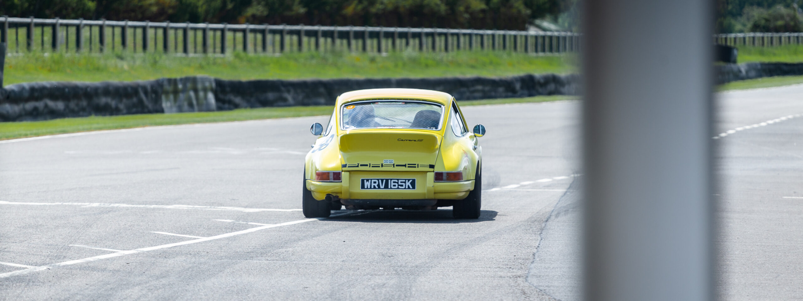 Yellow 911 RS leaving the Goodwood pits